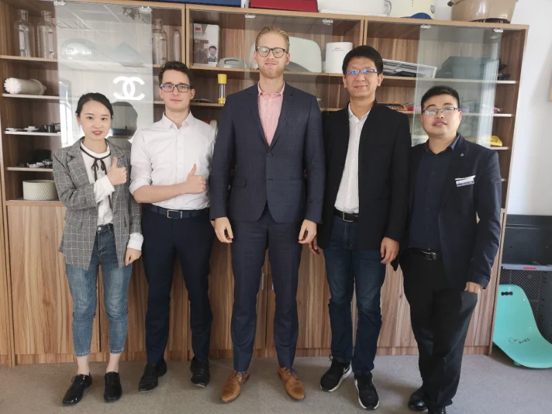 Group of visitors and staff standing in front of HVACore reception desk with company logo on the wall and Chinese lantern decorations hanging from the ceiling