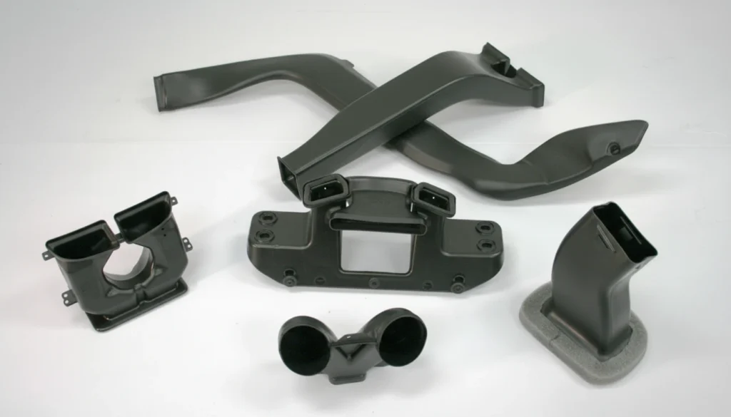 Black plastic HVAC components displayed on a warm gradient background, showcasing their design and engineering.